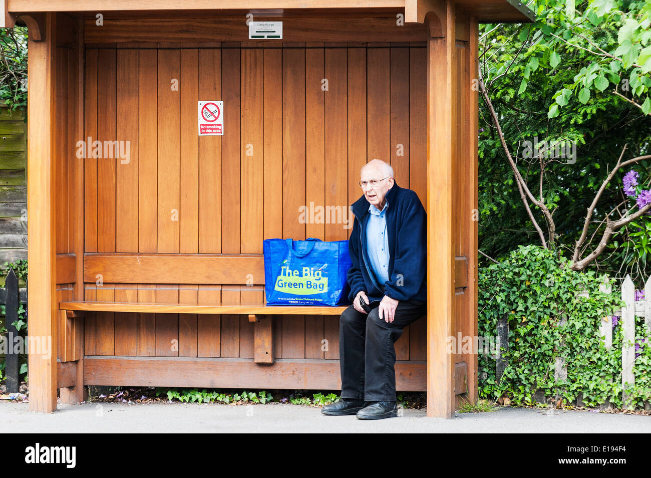 A male pensioner waiting for a bus. Stock Photo