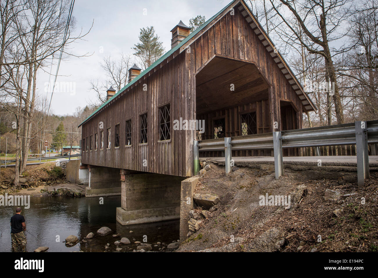 A man fishes on Little Pigeon River, by the Emerts Cove Covered Bridge in Pittman Center, Tennessee Stock Photo