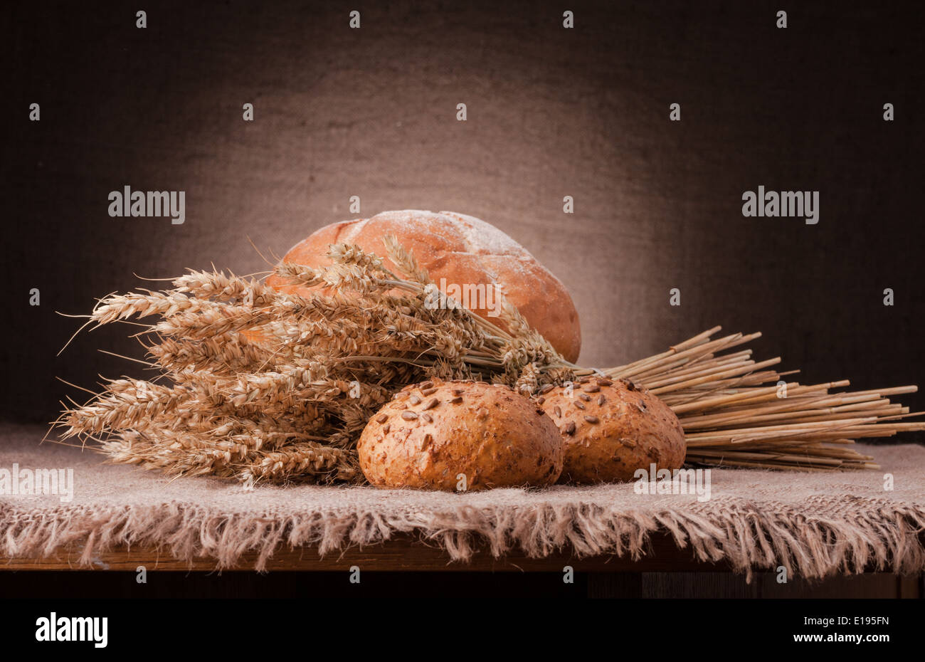 Loaf of bread and wheat ears still life on rustic background Stock ...