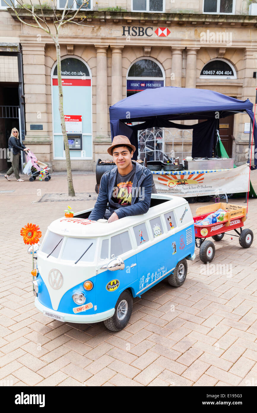 Young Man, driving a miniature Volkswagen car, with red open trailer, Newcastle Under Lyme, England Stock Photo