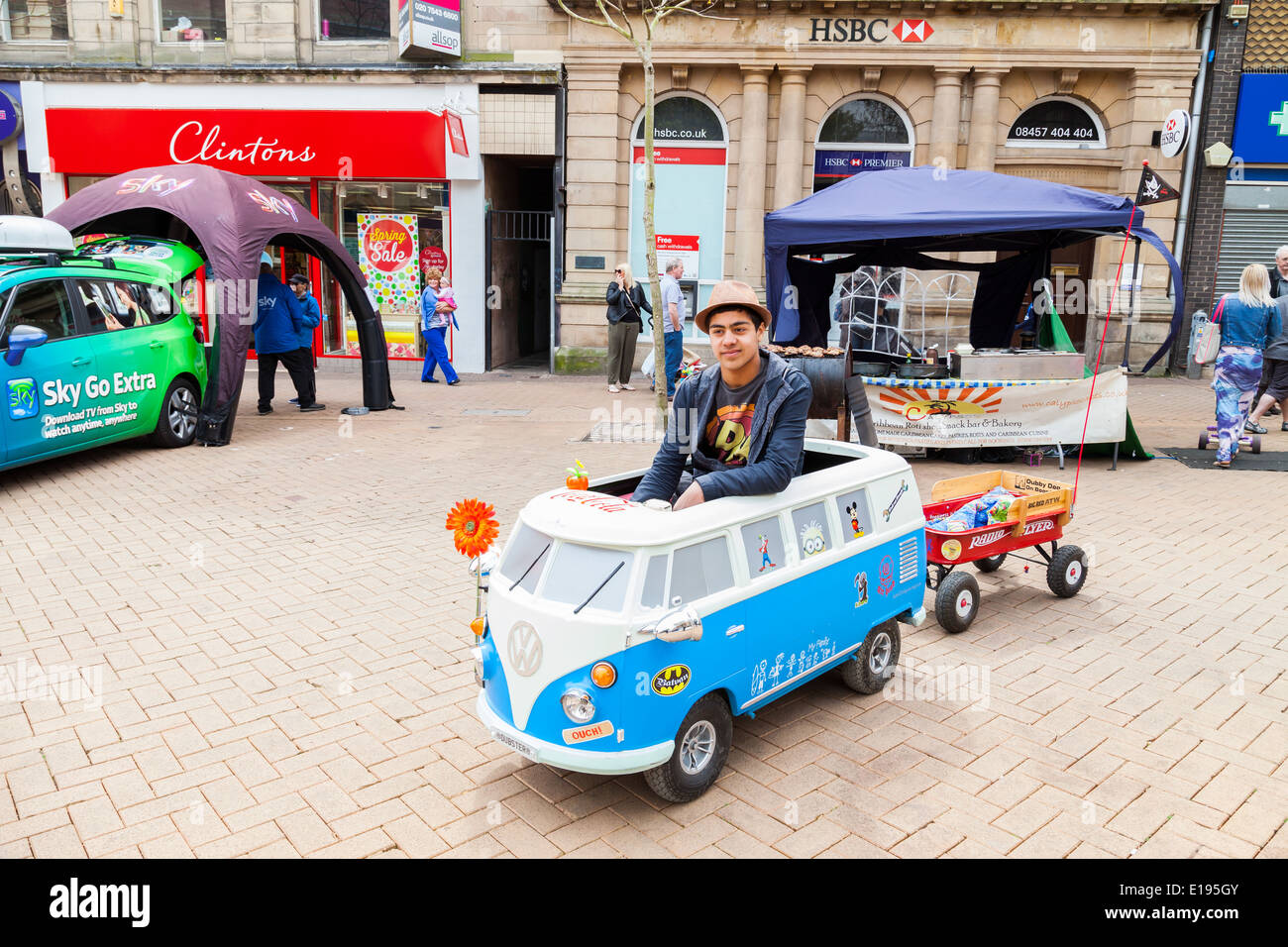 Young Man, driving a miniature Volkswagen car, with red open trailer, Newcastle Under Lyme, England Stock Photo