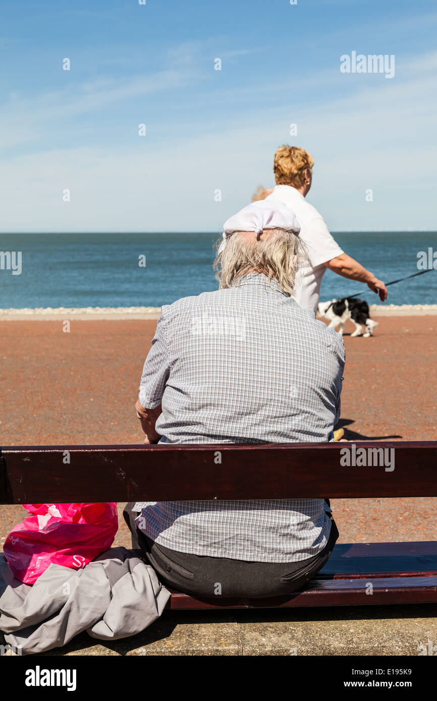 Elderly man, sitting on a wooden bench, with knotted handkerchief on his  head, Llandudno, North Wales Wales Stock Photo - Alamy