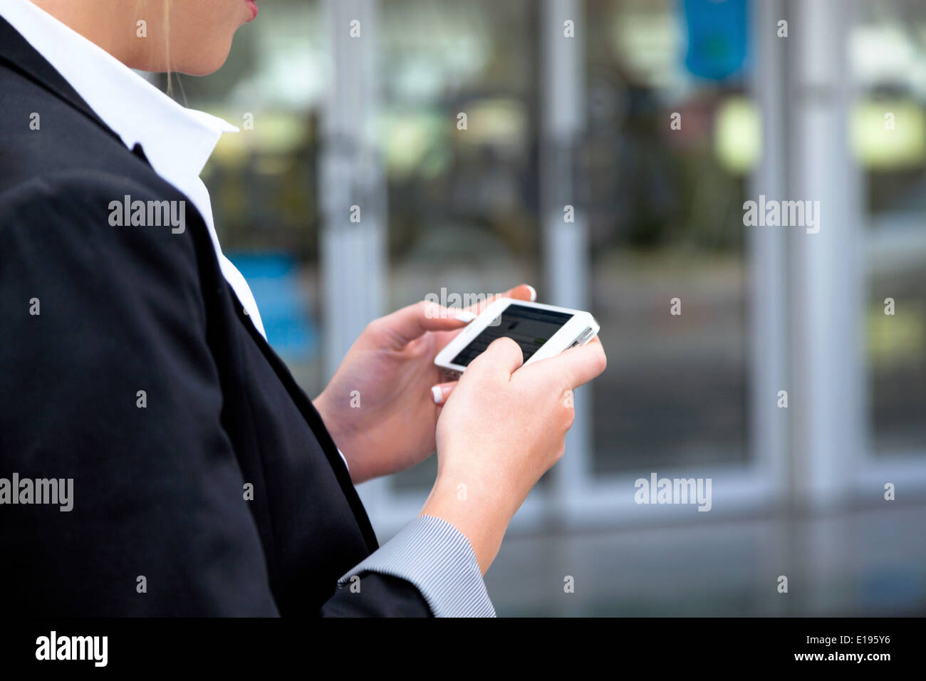 Gesch‰ftsfrau schreibt am Flughafen SMS. Roaming Geb¸hren im Ausland. Erreichbarkeit mit moderner Technik Stock Photo