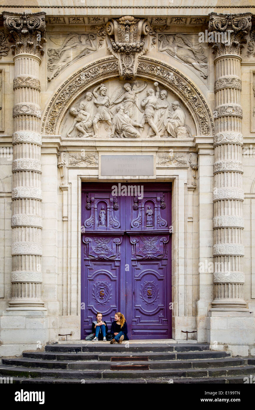Two girls at the huge wooden doors to Saint Etienne duMont Church