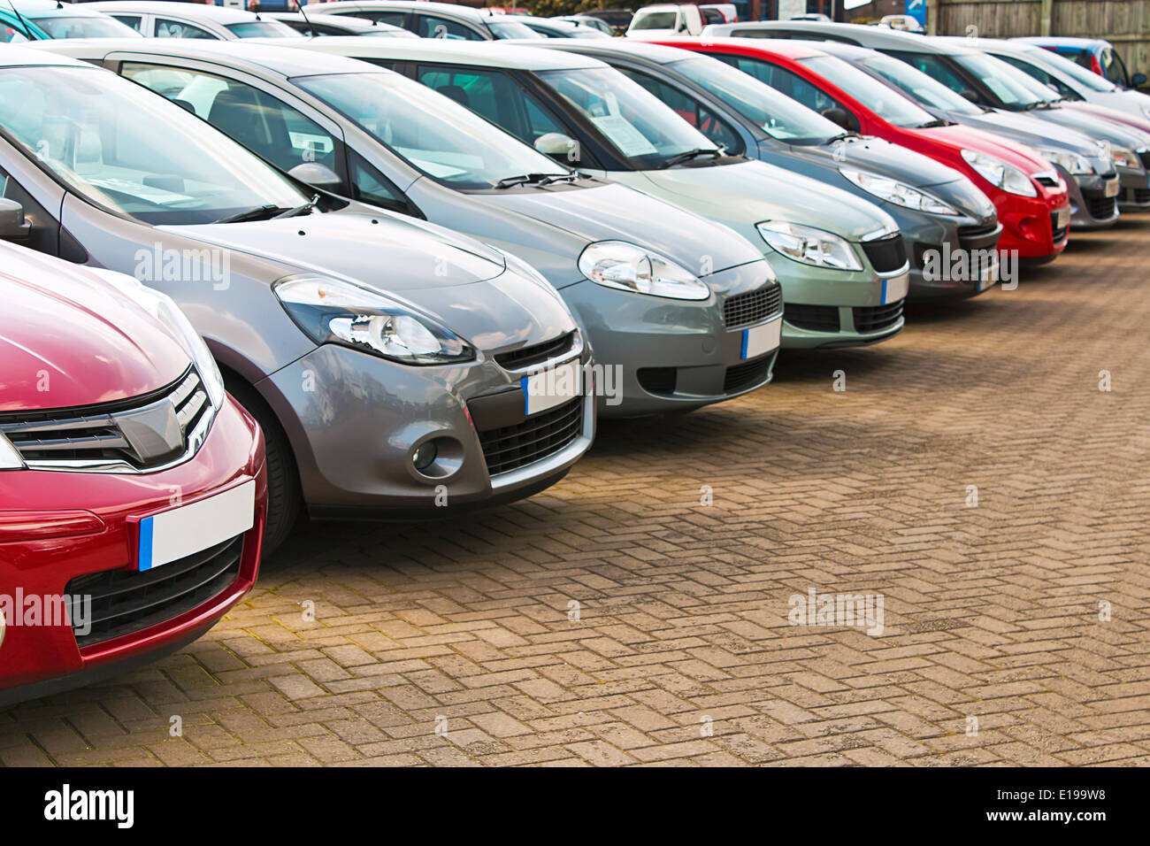 Line up of various types of used cars for sale on a motor dealers forecourt all marques removed Stock Photo