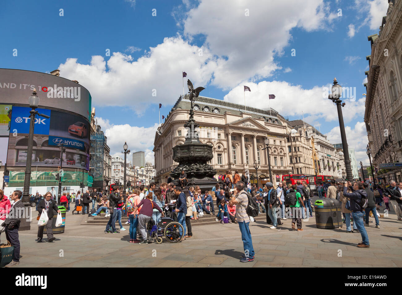 Crowds of tourists around Eros in a sunny Piccadilly Circus London Stock Photo