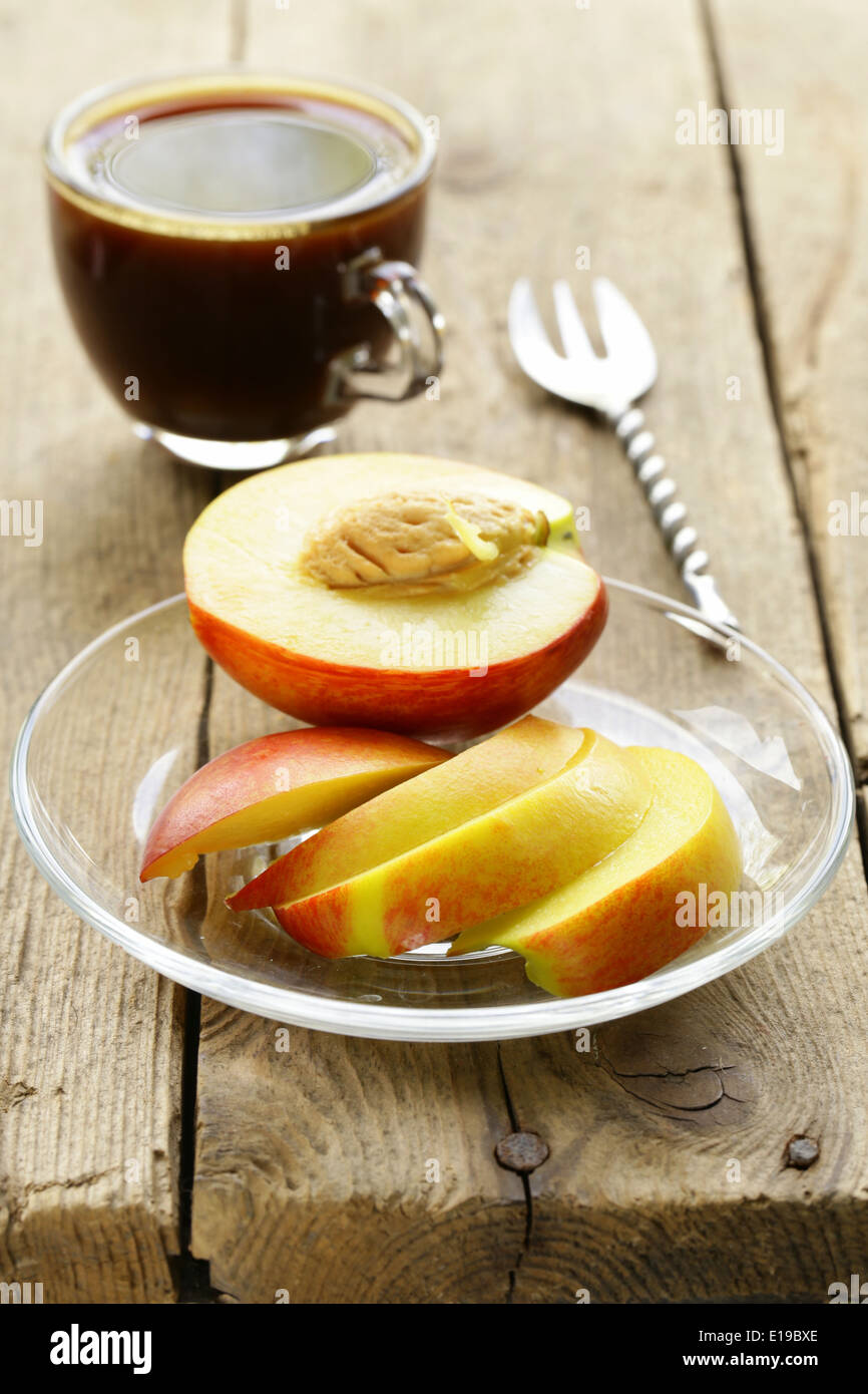 chopped fresh peach with a cup of coffee for breakfast Stock Photo