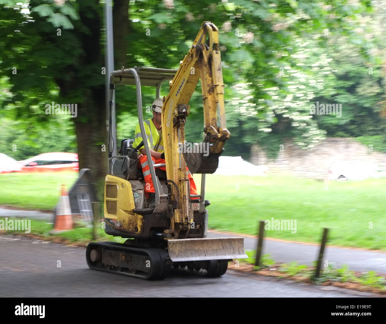 Mini digger excavator traveling up early morning prior to the start of the days work. 22 May 2014 Stock Photo