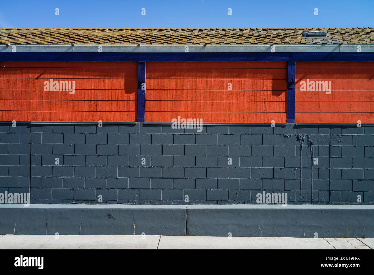 Side of brightly colored building with orange insets and purple ...