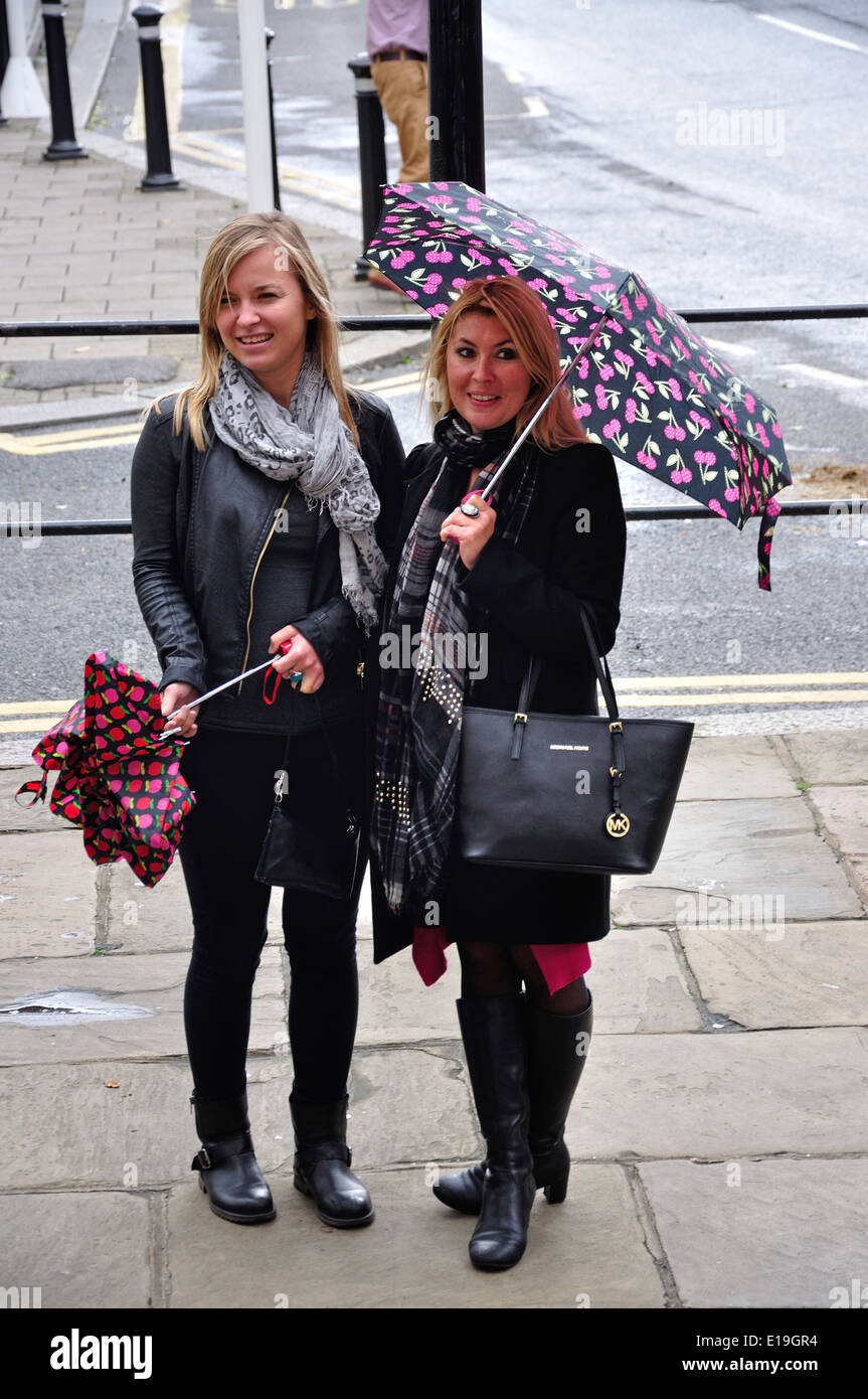 Young women with umbrellas, High Street, Windsor, Berkshire, England, United Kingdom Stock Photo