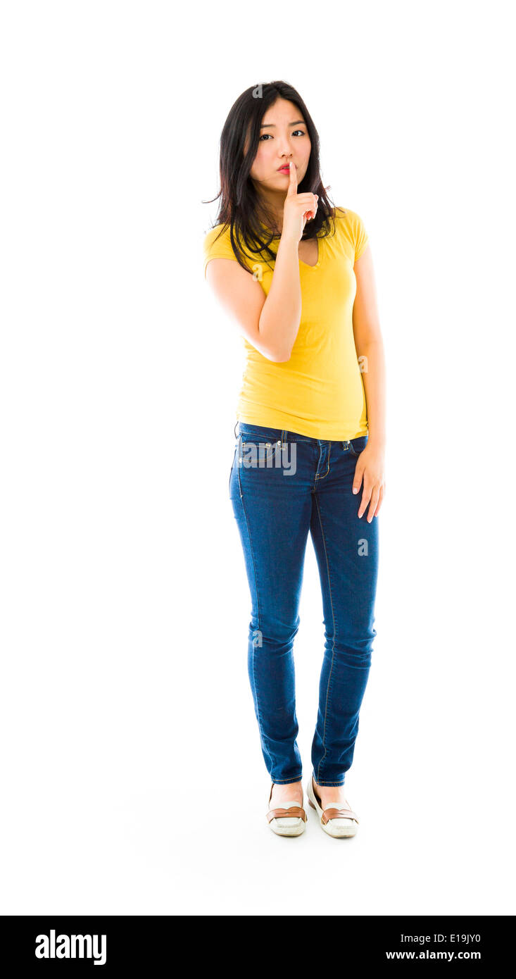 Young Asian woman standing with finger on lips Stock Photo - Alamy