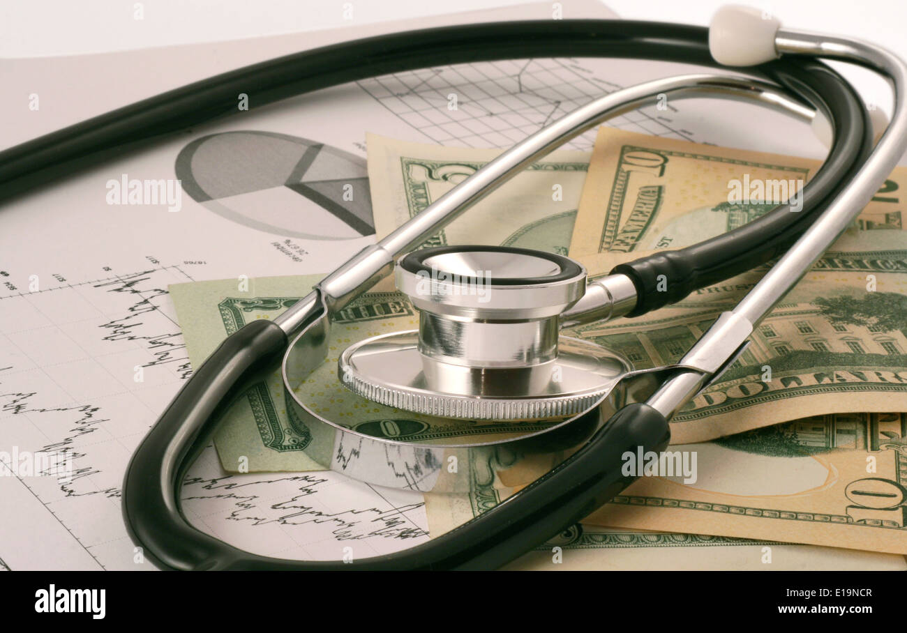 On a paper with economic graphs lie dollars and stethoscope. Financial graphs, money and stethoscope Stock Photo