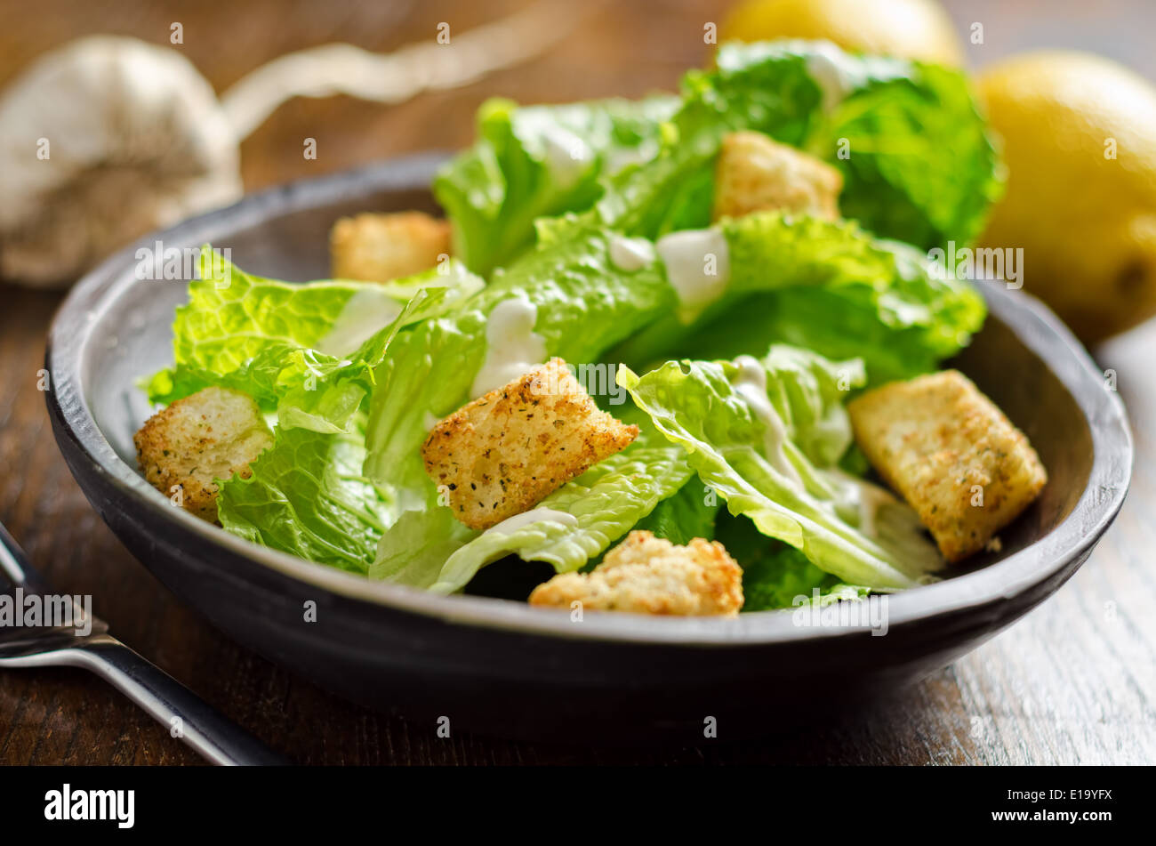 A crispy caesar salad with romaine lettuce, croutons, lemon, and garlic