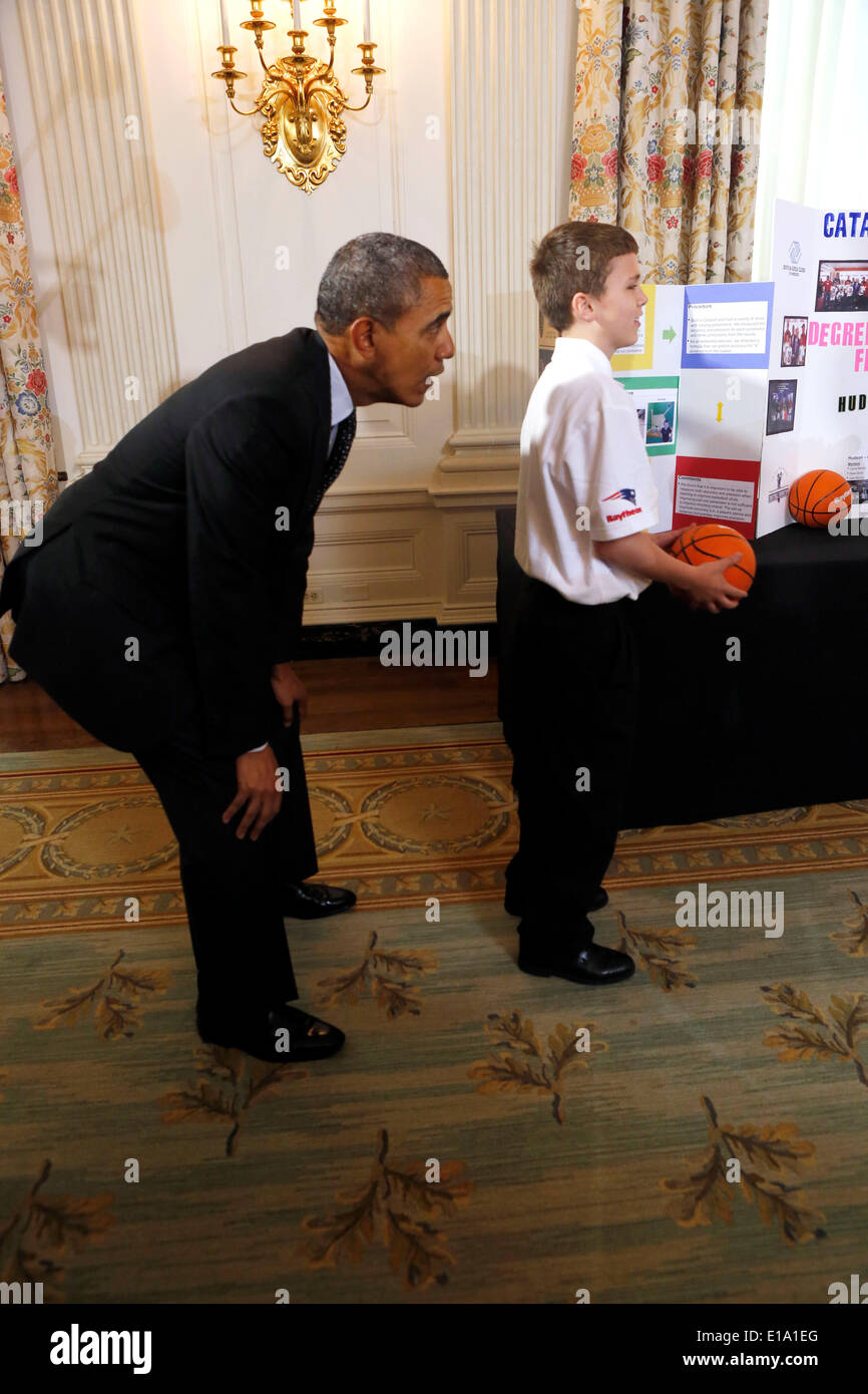 Washington DC, USA. 27th May, 2014. United States President Barack Obama catches a ball from the 'Basketball Catapult' a science project of Brooke Bohn (unseen), Daisjaughn Bass (unseen) and Gerry McManus (r), from Hudson Massachusetts, winners of the Raytheon and New England Patriots Science of Sports during the 2014 White House Science Fair at the White House, Washington DC, Tuesday May 27, 2014. The Fair celebrates the winners of STEM (science, technology, engineering and math) competitions across the country. Credit:  dpa picture alliance/Alamy Live News Stock Photo