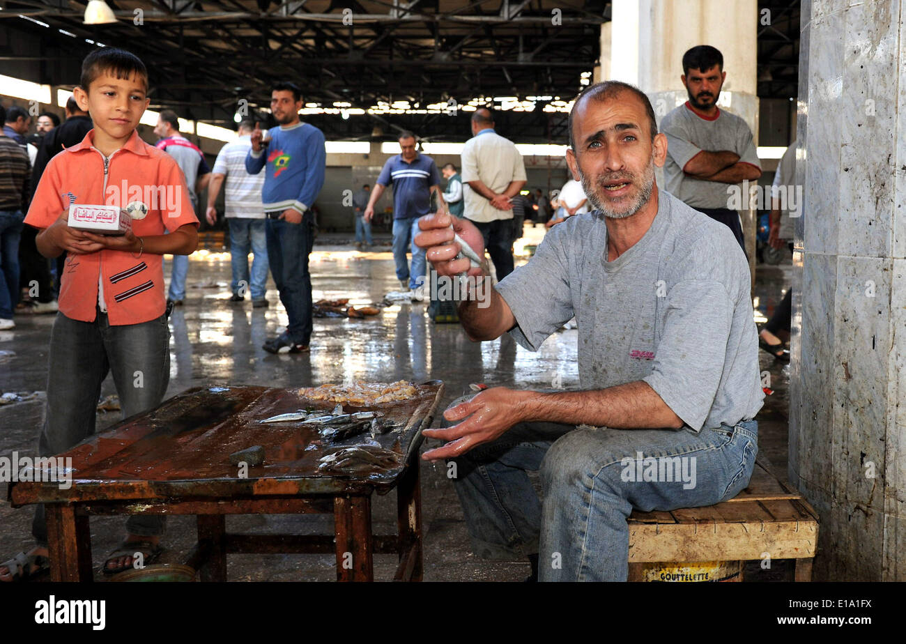 Lattakia, Syria. 26th May, 2014. A man shows his newly caught fish at the central fish market in Lattakia, Syria, May 26, 2014. © Zhang Naijie/Xinhua/Alamy Live News Stock Photo