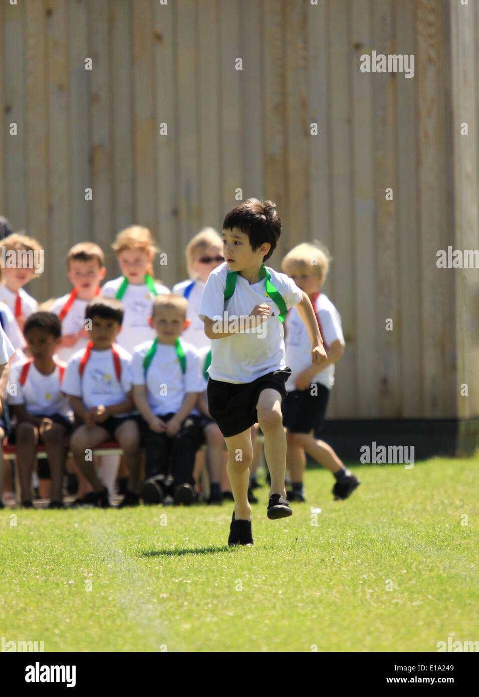 Young boy competing in running race on sportsday Stock Photo