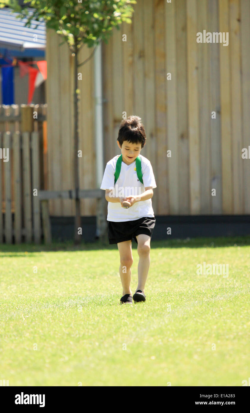 Young boy competing in egg and spoon race on sportsday Stock Photo