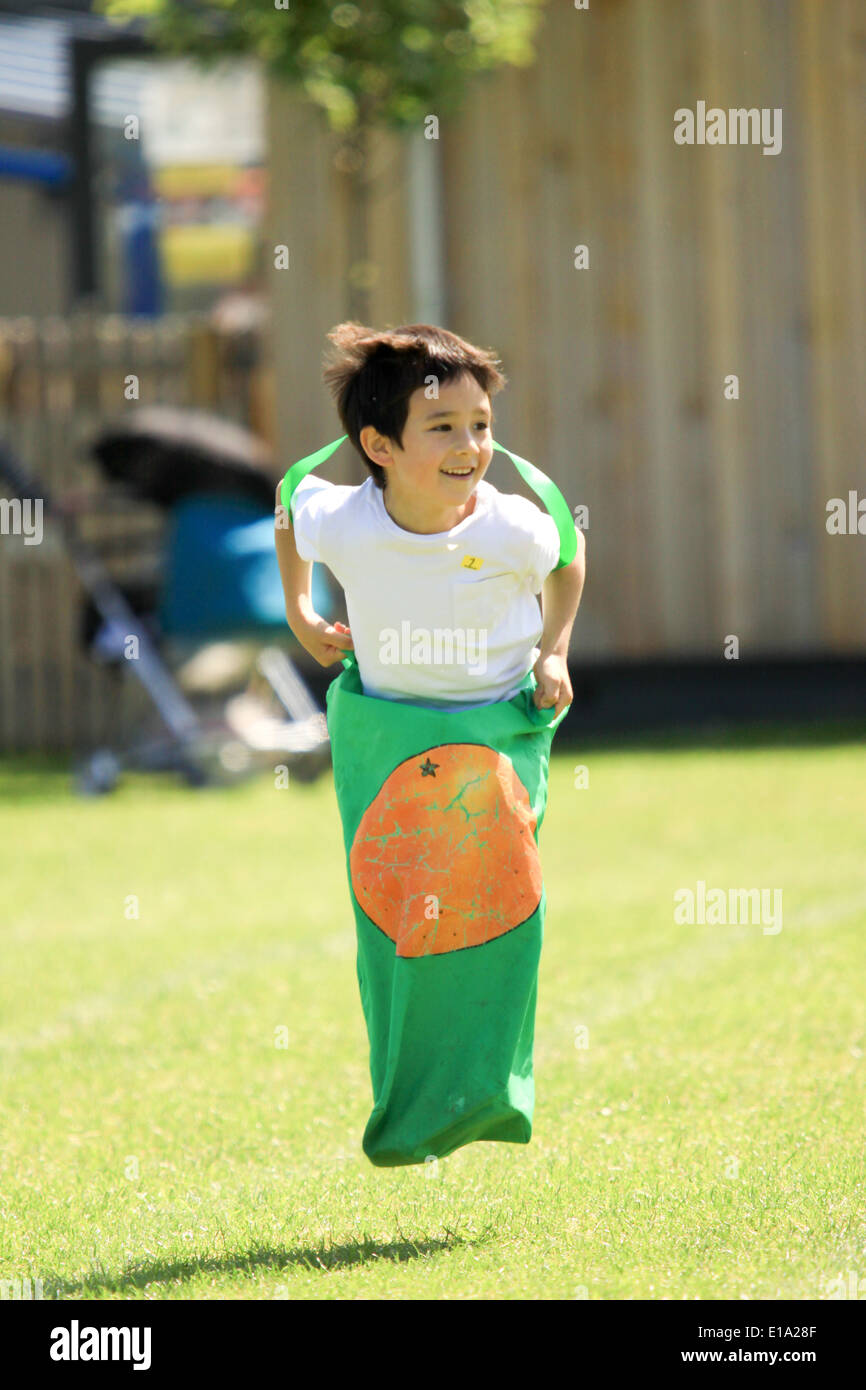 Young boy competing in sack race on sportsday Stock Photo