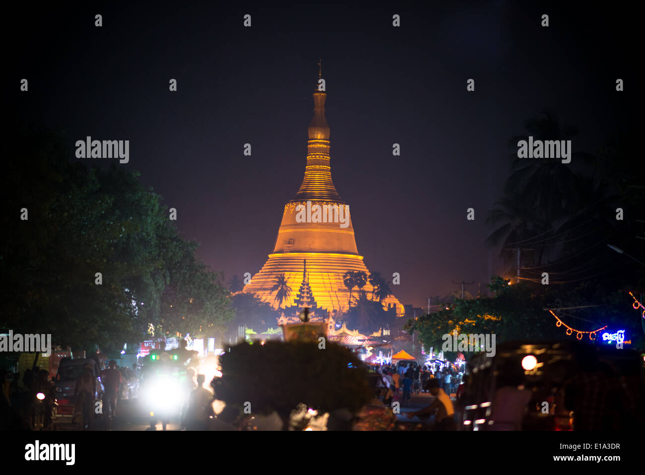 Shwemawdaw Paya stands 114 meters high above the sacred city of Bago, Myanmar and glows orange over the night sky. Stock Photo