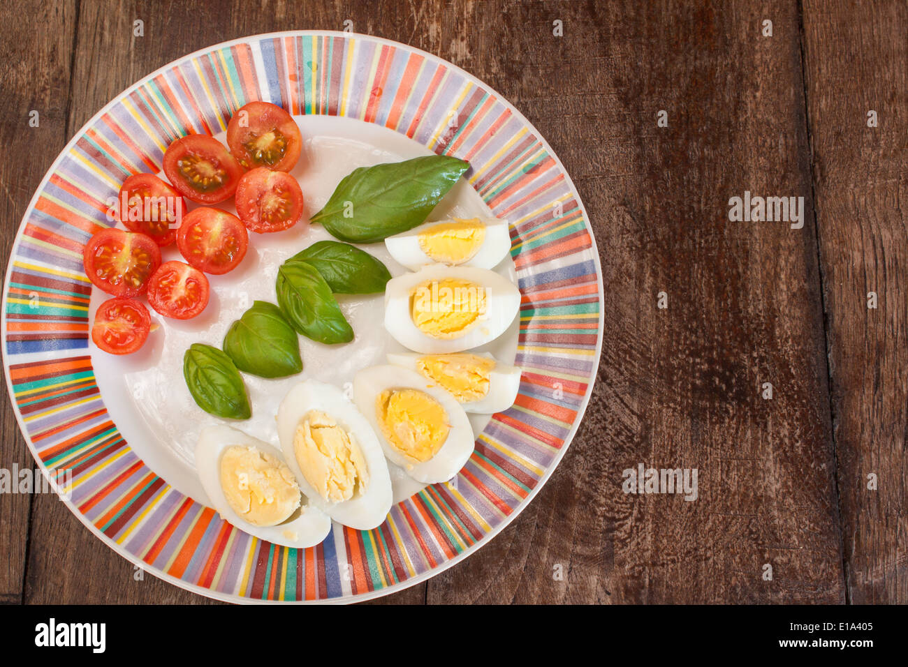 'cherry tomatoes' tomato halved basil leaves eggs plate colorful 'top view' 'from above' wood 'copy space' nobody breakfast Stock Photo
