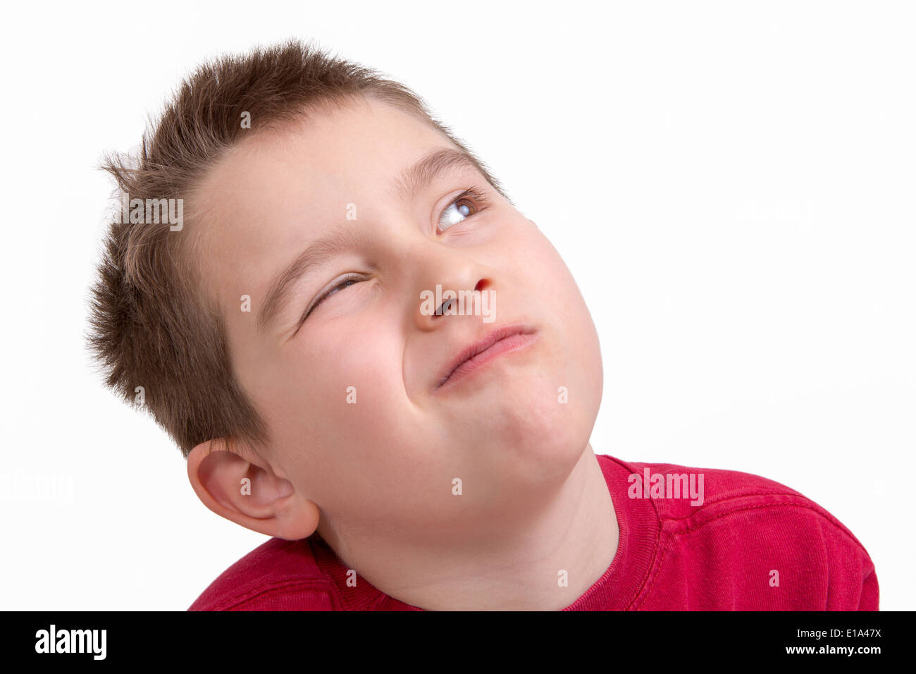 Nine years old kid giving a choosy look with one eye closed Stock Photo