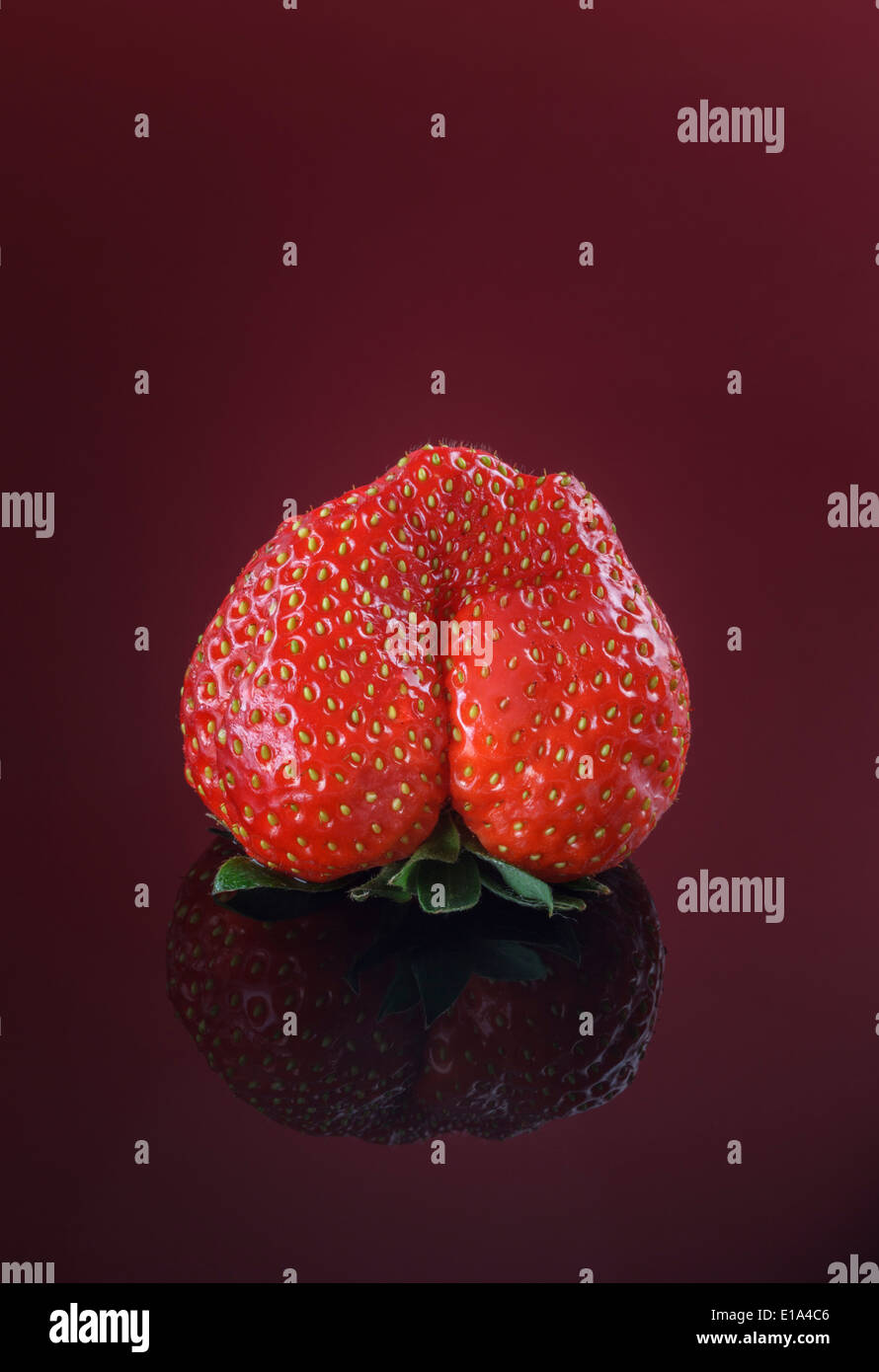 Single fresh Strawberry on red background Stock Photo