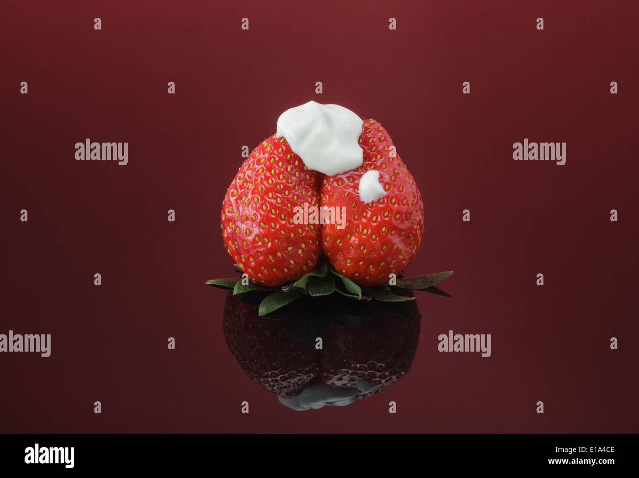 Single fresh Strawberry topped with natural thick Yogurt Stock Photo