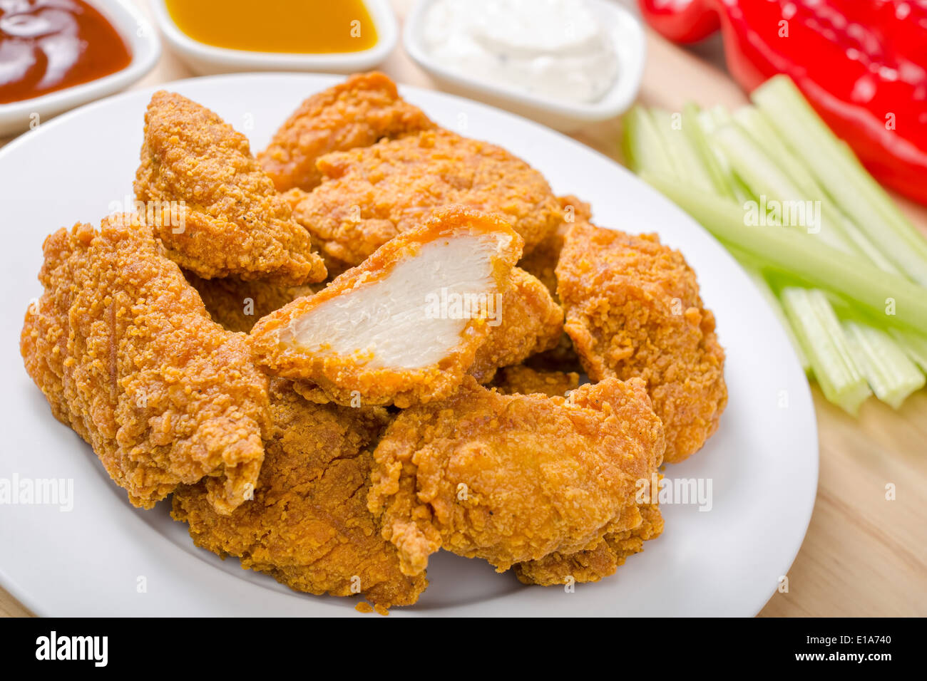 Crispy chicken nuggets with three dipping sauces. Stock Photo