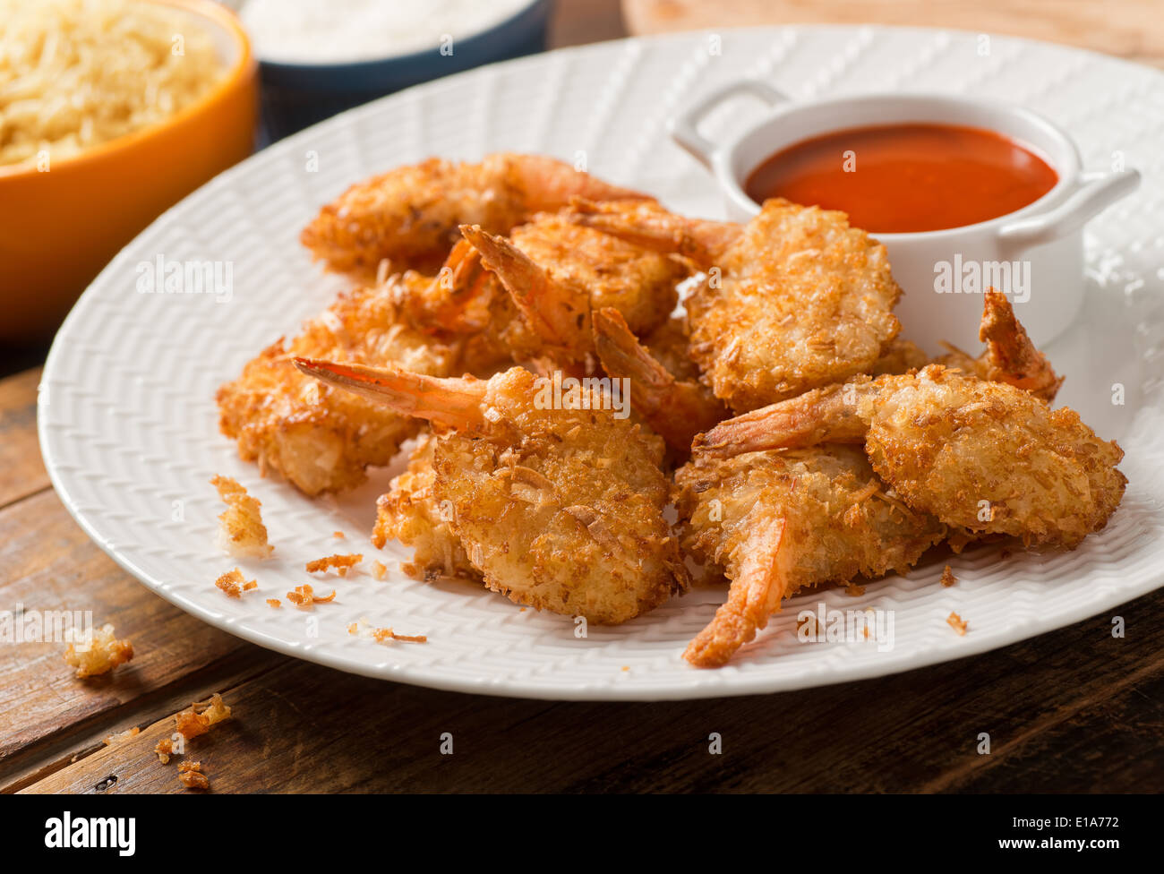 Delicious golden breaded and deep fried coconut shrimp with dipping sauce. Stock Photo