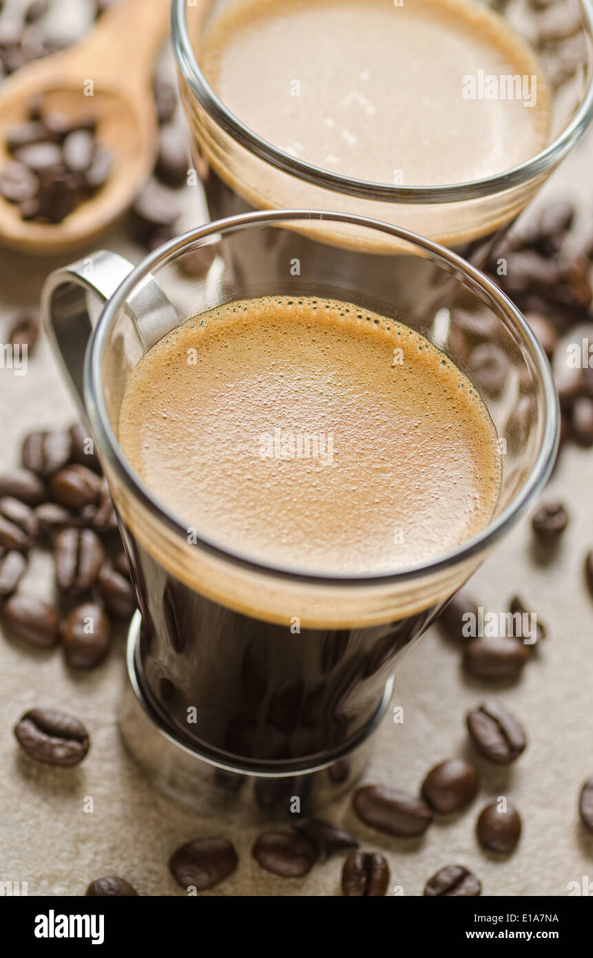 Two cups of freshly brewed espresso coffee with roasted coffee beans. Stock Photo
