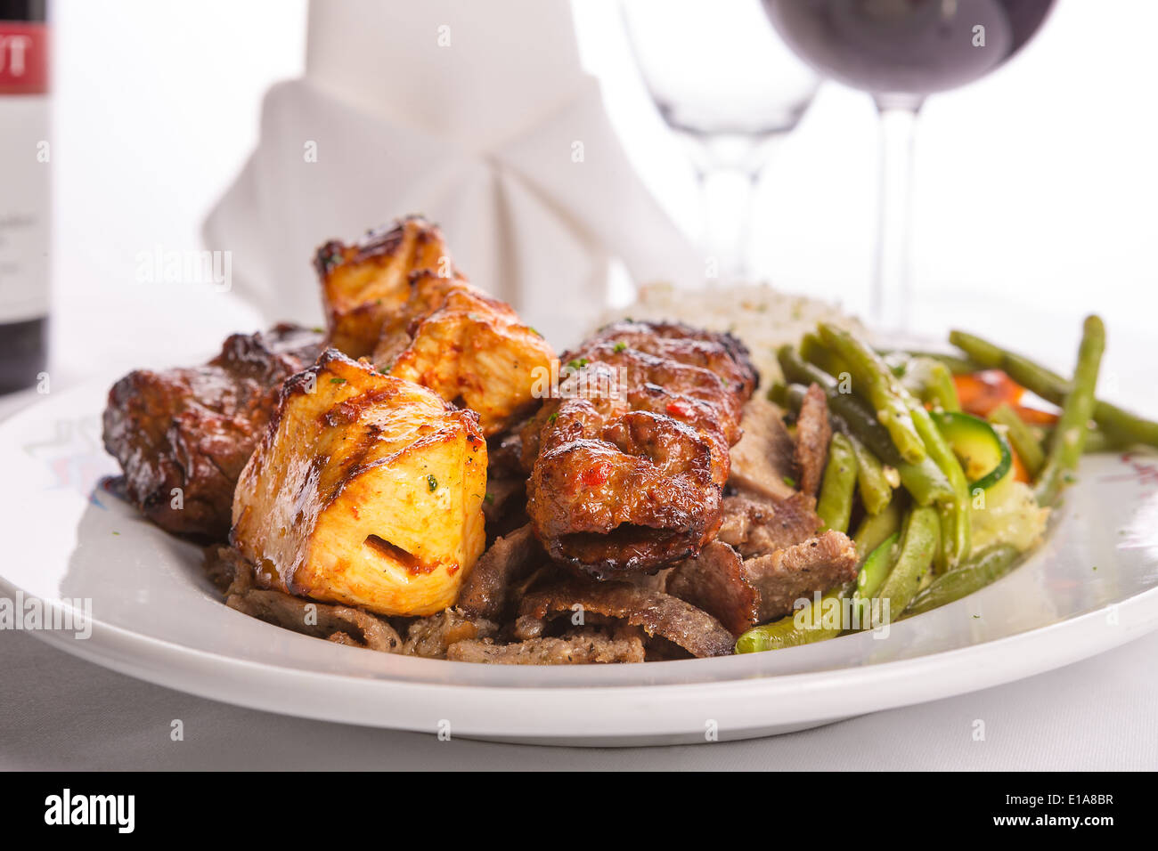 Mixed chicken, lamb adana shish kebabs served served on gyro doner with