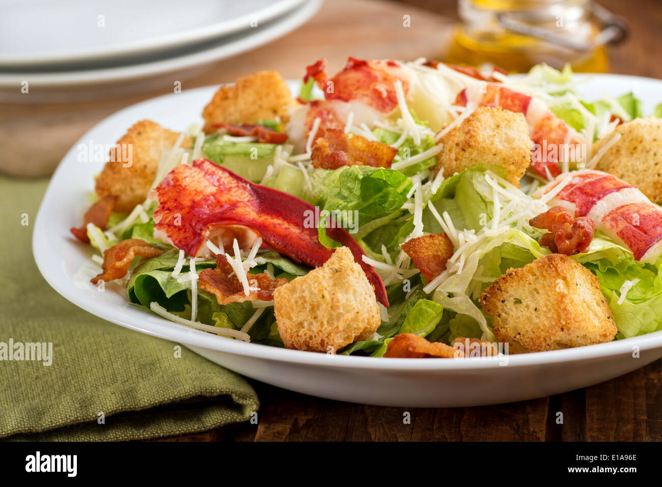 A crisp green lobster caesar salad with shredded parmesan cheese, crispy bacon, and herb croutons. Stock Photo