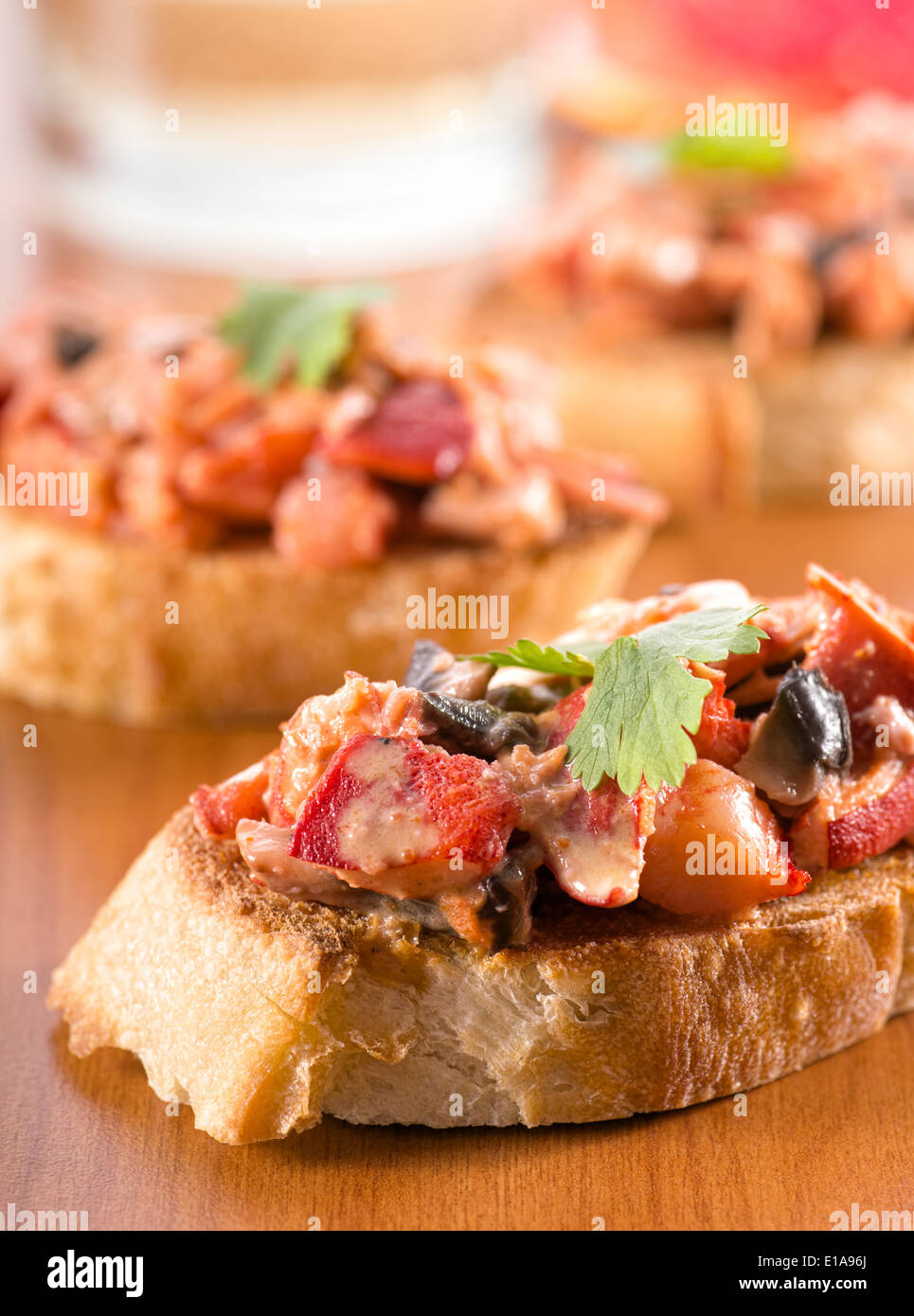 Lobster with mushrooms in a creamy cheese sauce on toasted french bread baguette. Stock Photo