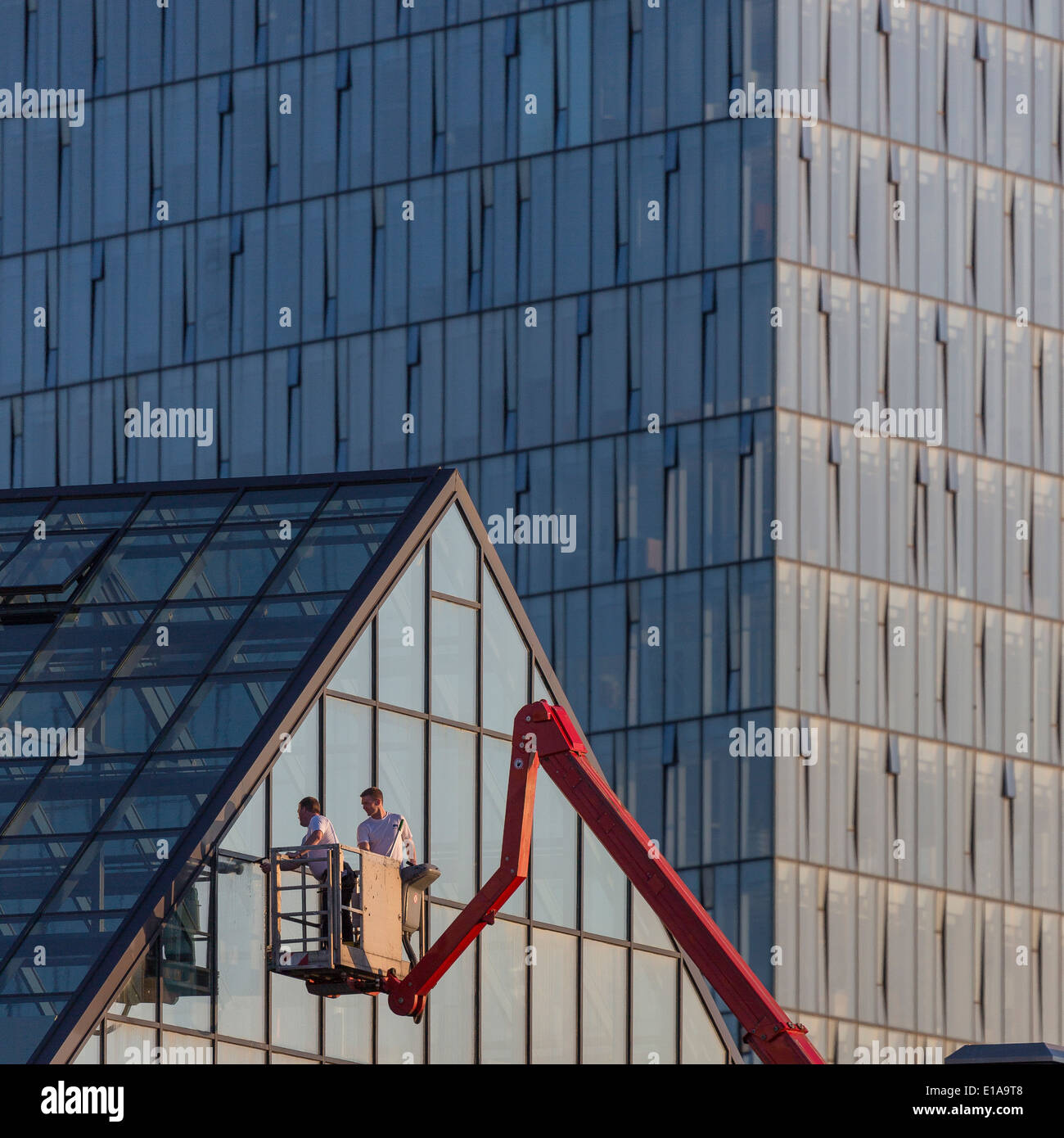 Working on the exterior of a glass building, Reykjavik, Iceland Stock Photo