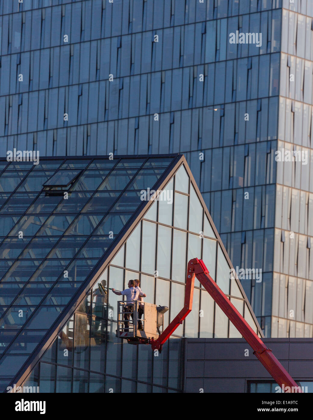 Working on the exterior of a glass building, Reykjavik, Iceland Stock Photo