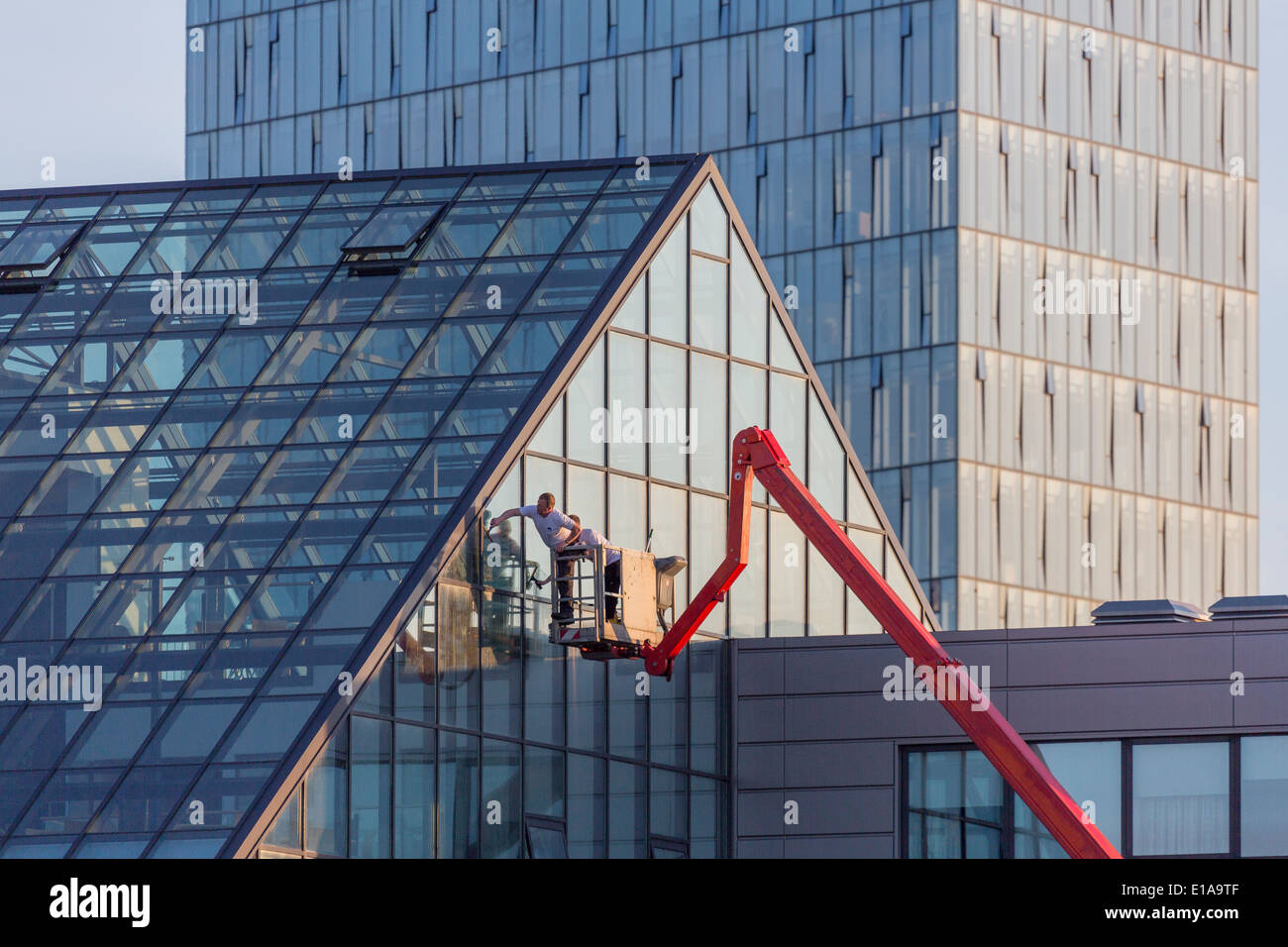Working on the exterior of a glass building, Reykjavik, Iceland Stock Photo
