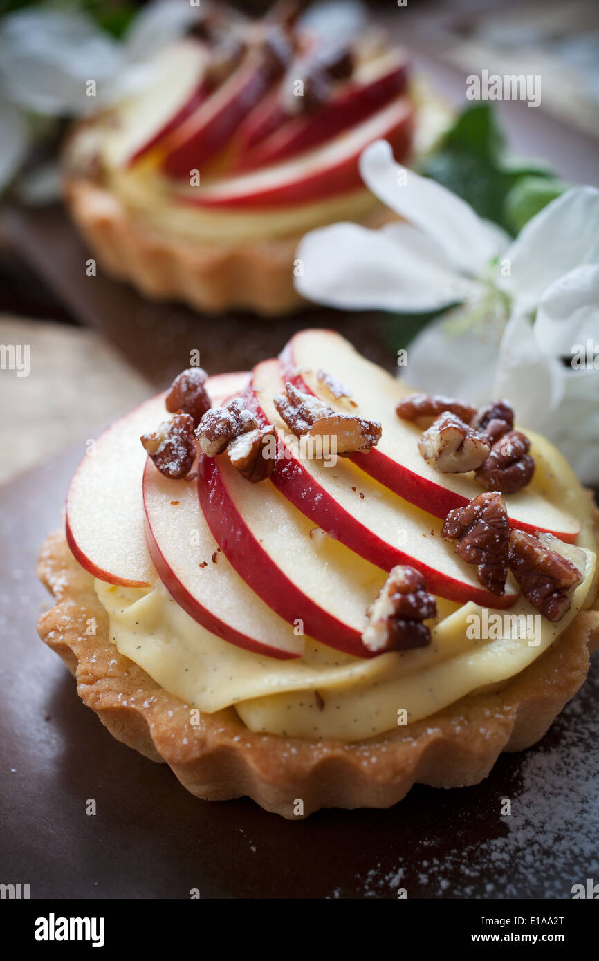 Tartlets with apple slices, cream and pecan filling Stock Photo