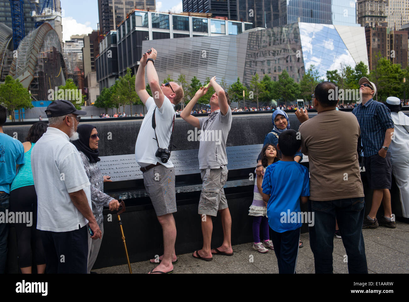Visitors take pictures in the ground zero area of the 911 memorial