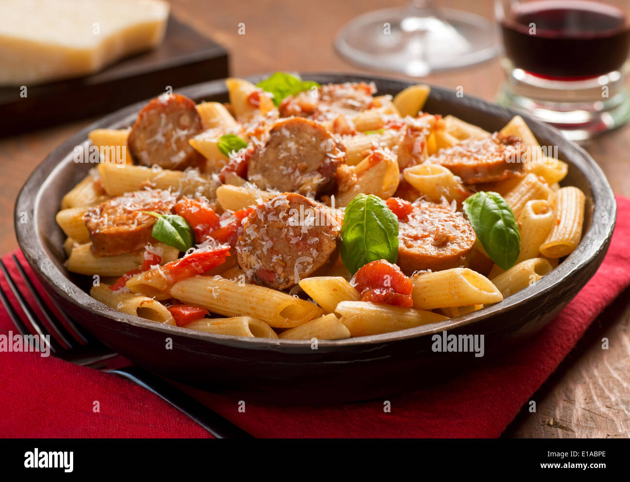 Cajun style pasta with penne, spicy sausage, red peppers, and tomato sauce with freshly grated parmesan cheese. Stock Photo