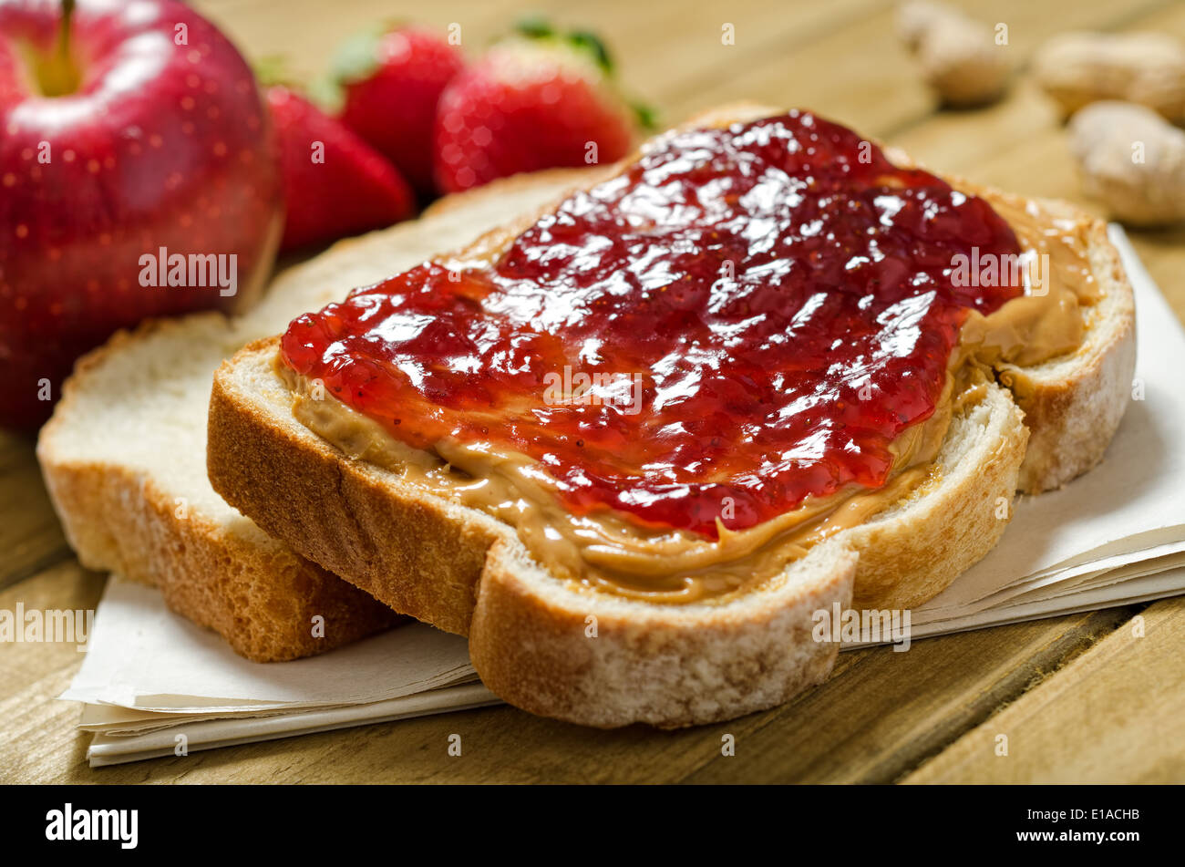 A nutritious peanut butter and jelly sandwich with apples, strawberries