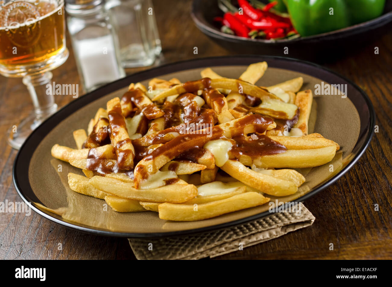 A plate of delicious poutine with french fries, gravy, and cheese curd. Stock Photo