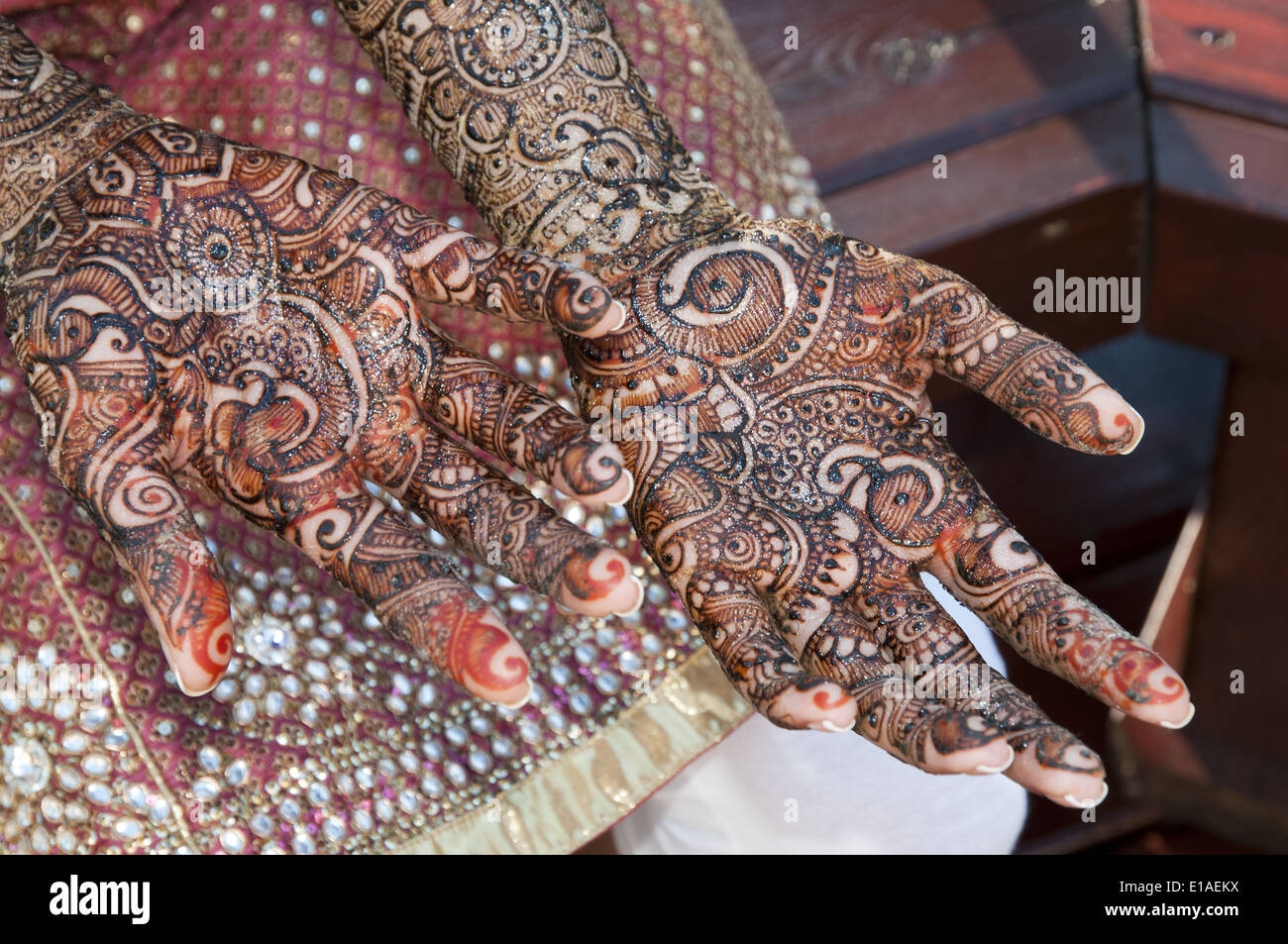 Indian bride to be getting her arms and legs decorated with henna at a ...