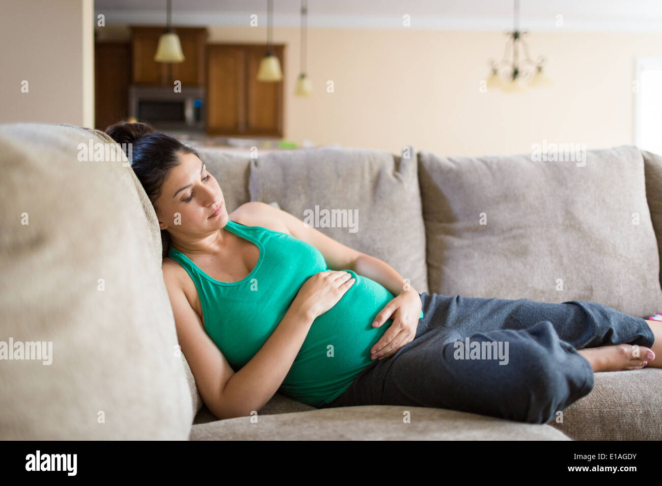 Pregnant woman laying on the couch to rest Stock Photo Alamy