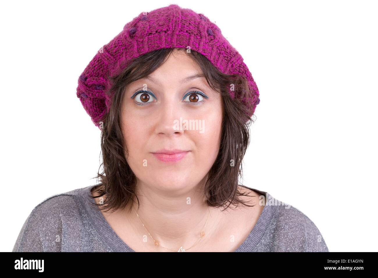 Attractive woman wearing a purple knitted winter cap opening her eyes wide in astonishment and skepticism to show her disbelief, Stock Photo