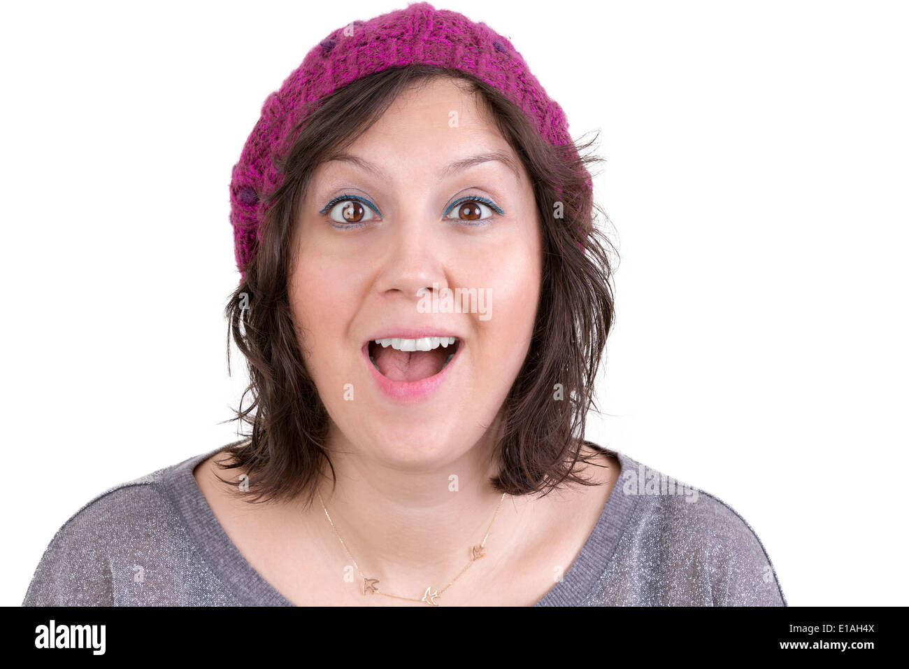 Attractive woman in a knitted cap reacting in delight and pleasure with sparkling eyes and her mouth open wide, isolated on whit Stock Photo
