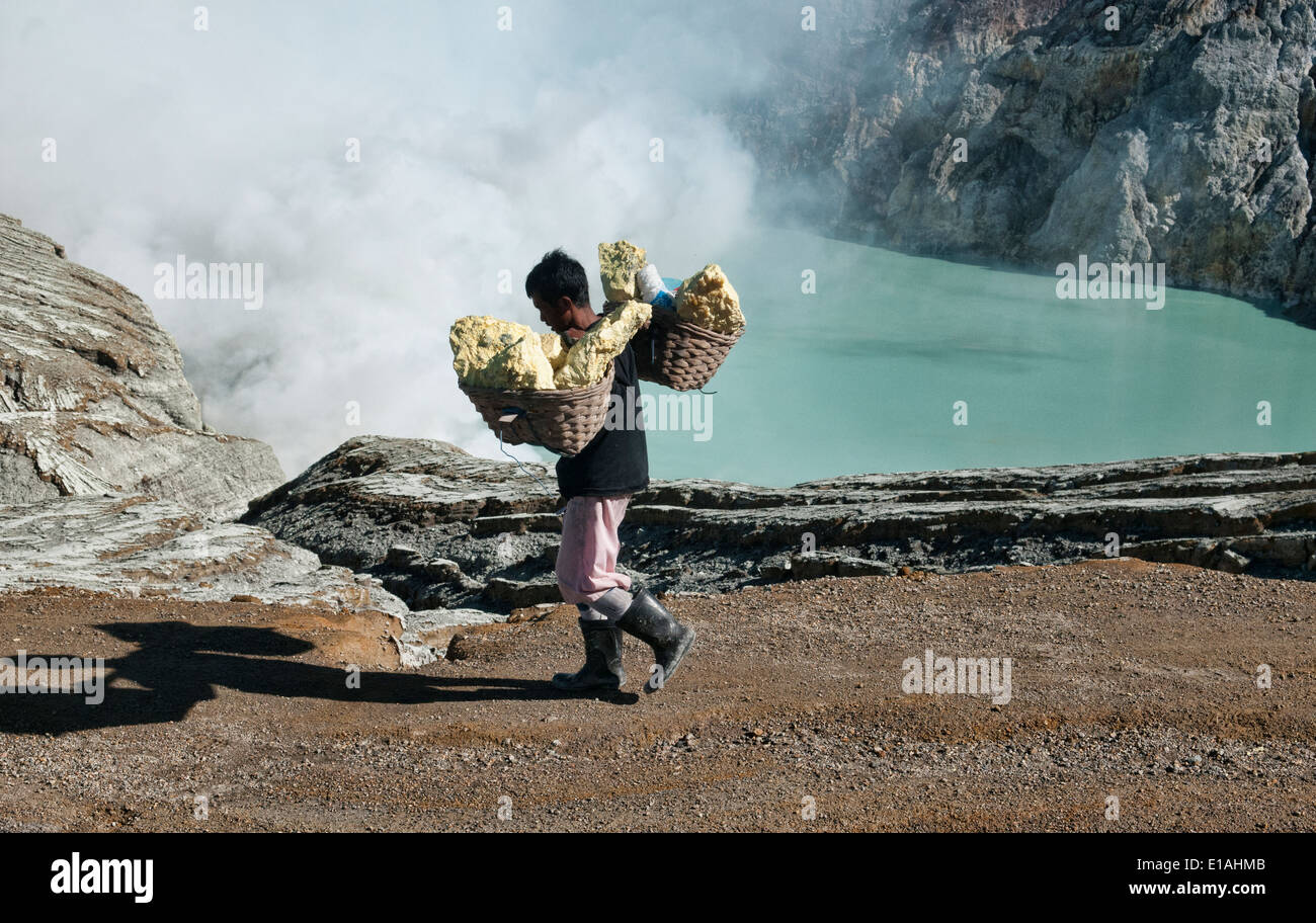 Miner carrying a heavy load of sulphur at the Kawah Ijen volcanic ...
