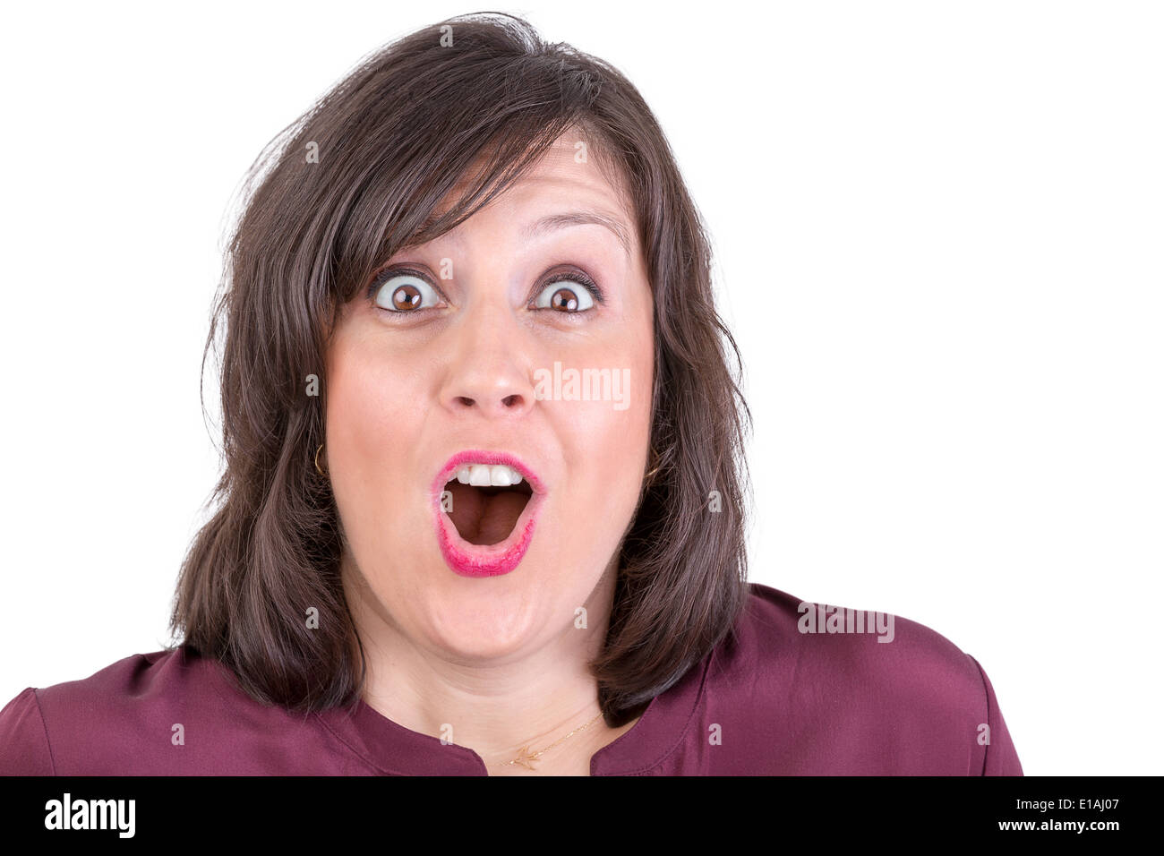 Happily amazed dark haired lady looking in to your eyes with her mouth wide open Stock Photo