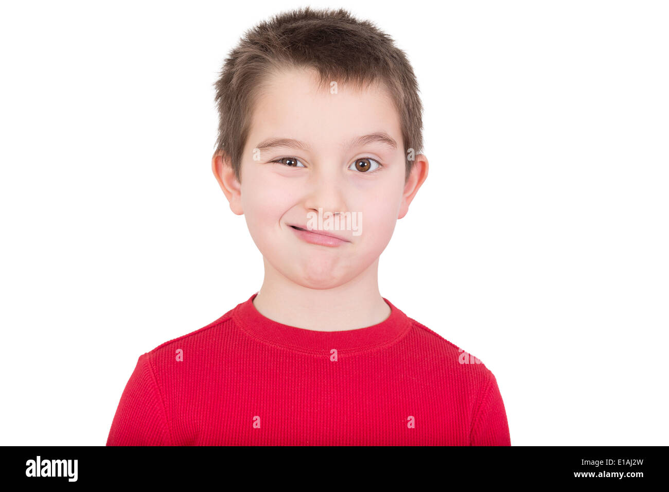 Cute playful young boy in a colorful red t-shirt standing winking at the camera, head and shoulders portrait isolated on white Stock Photo