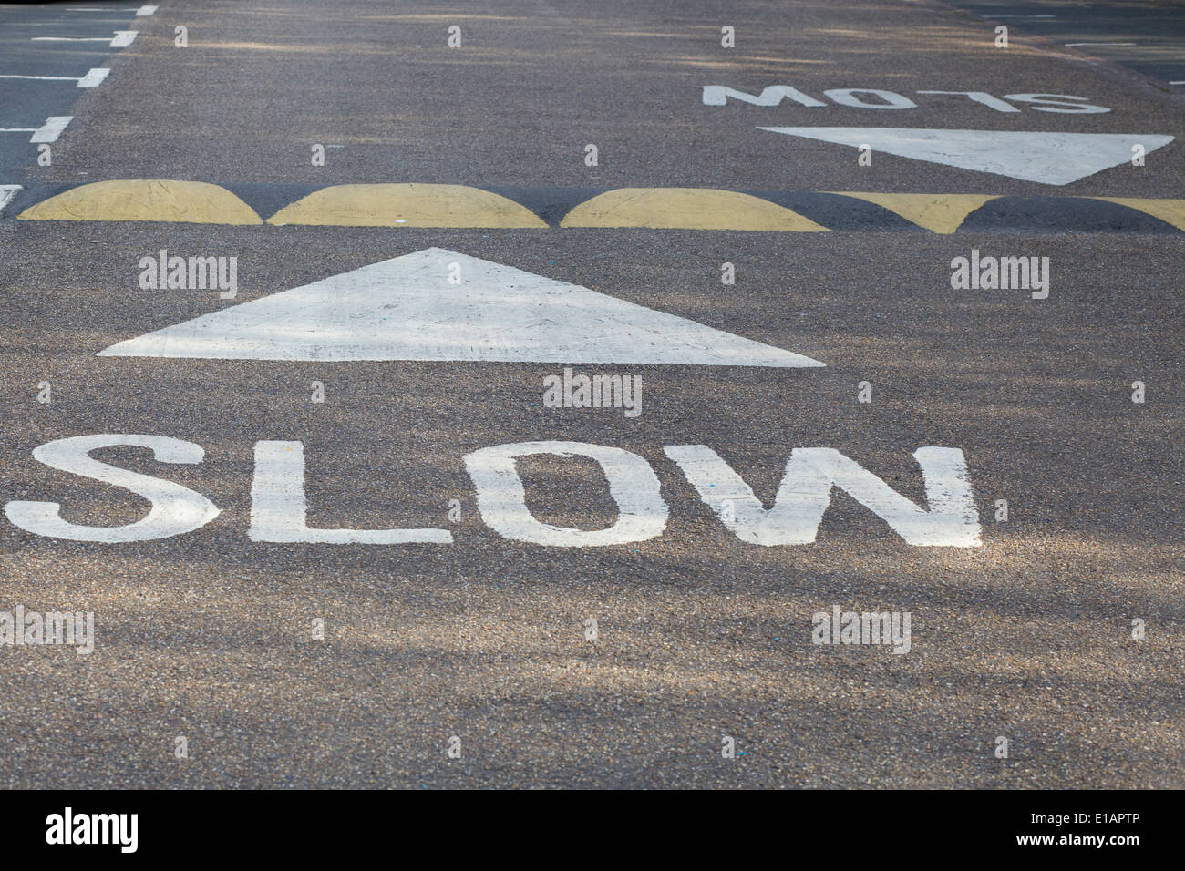 Road markings and tarmac signage with sleeping police man Stock Photo