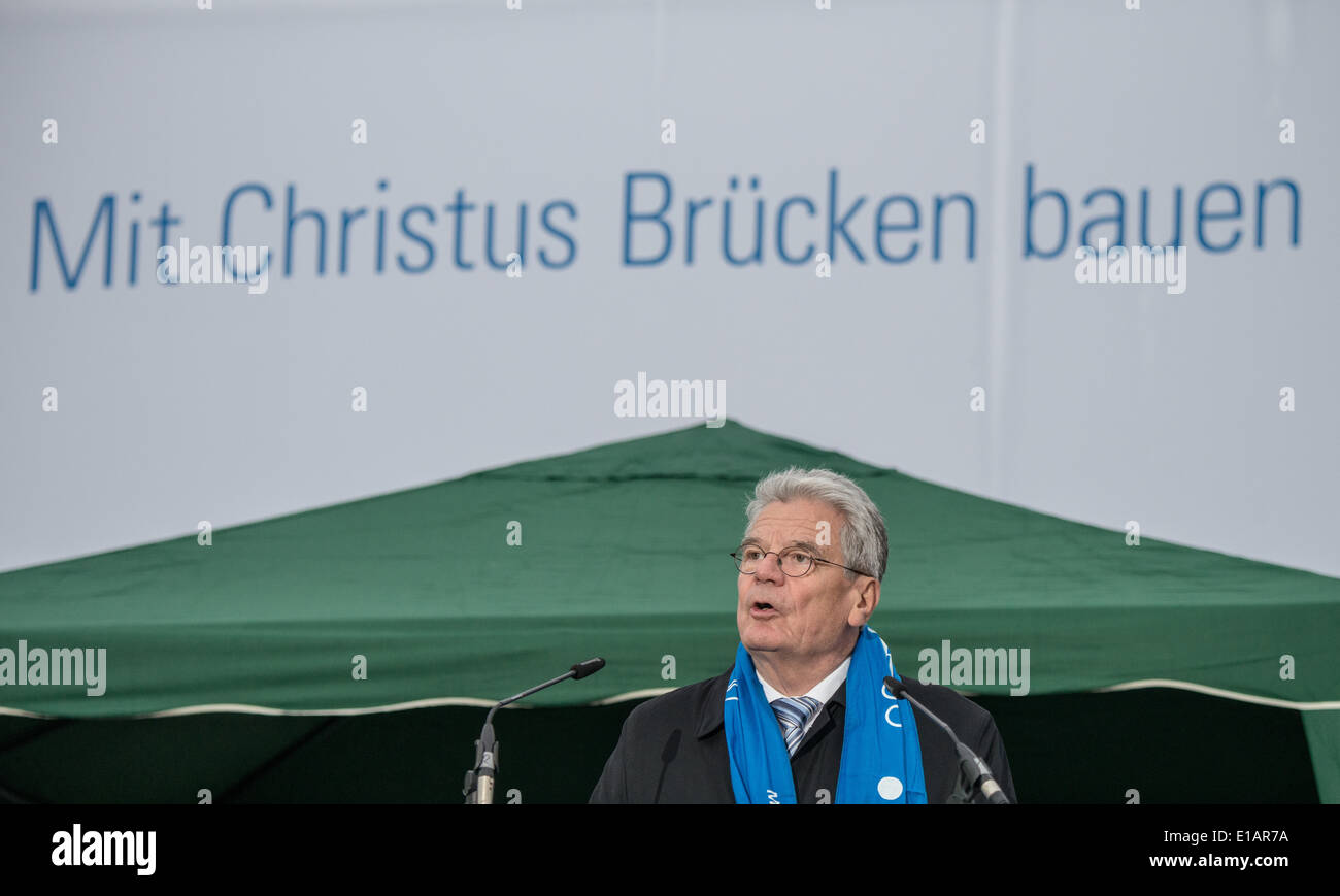 Regensburg, Germany. 28th May, 2014. President of Germany, Joachim Gauck, speaks in front of a banner which reads 'building bridges with Christ' during the opening ceremony of the 99th German Catholics Day in Regensburg, Germany, 28 May 2014. Ten-thousands of believers are expected in Regensburg for the five day event. Photo: ARMIN WEIGEL/dpa/Alamy Live News Stock Photo
